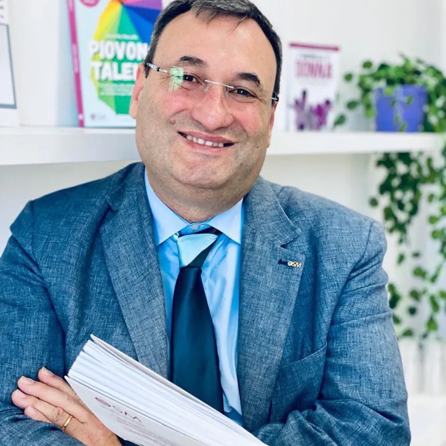 Baldassare Pipitone sorridente con un libro in mano