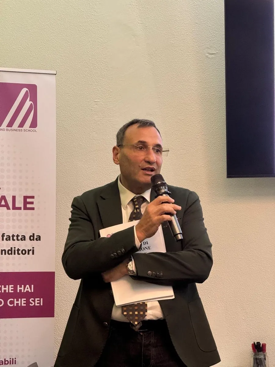 Baldo parla al microfono durante un incontro